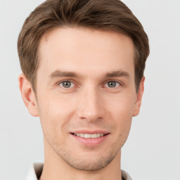 Joyful white young-adult male with short  brown hair and grey eyes