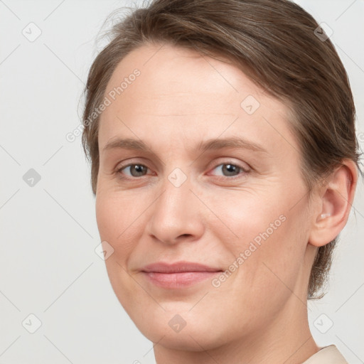 Joyful white young-adult female with medium  brown hair and grey eyes