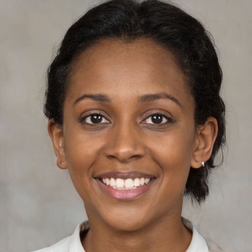 Joyful black young-adult female with medium  brown hair and brown eyes