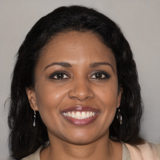 Joyful black young-adult female with long  brown hair and brown eyes