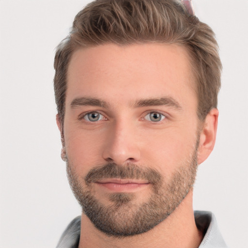 Joyful white young-adult male with short  brown hair and grey eyes