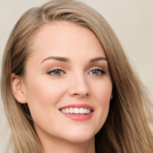 Joyful white young-adult female with long  brown hair and blue eyes