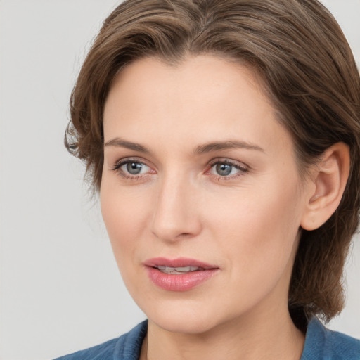 Joyful white young-adult female with medium  brown hair and blue eyes