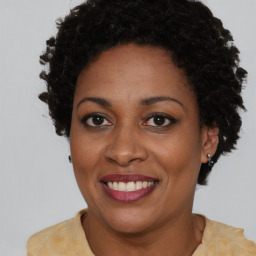 Joyful black adult female with short  brown hair and brown eyes