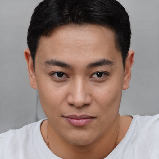Joyful asian young-adult male with short  brown hair and brown eyes