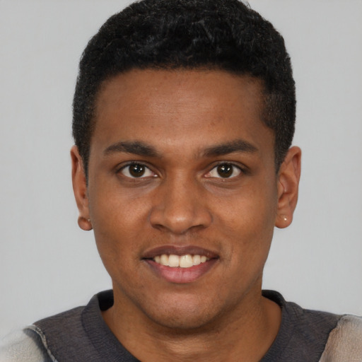 Joyful black young-adult male with short  black hair and brown eyes