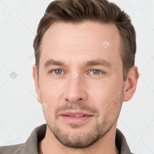 Joyful white young-adult male with short  brown hair and grey eyes