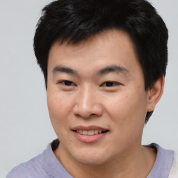 Joyful asian young-adult male with short  brown hair and brown eyes