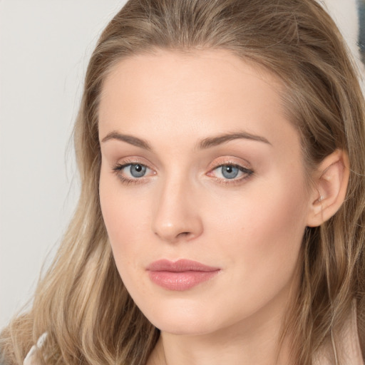 Joyful white young-adult female with long  brown hair and blue eyes