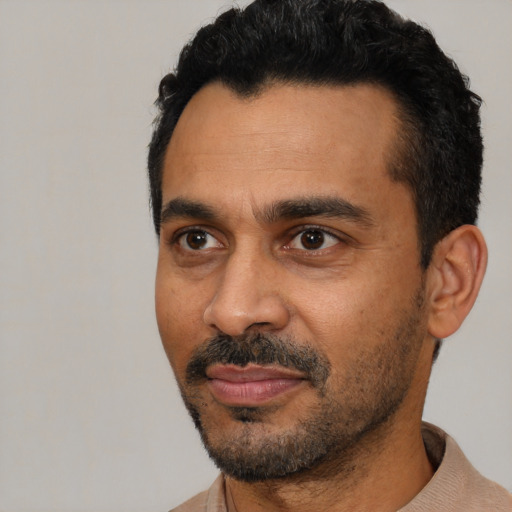 Joyful black adult male with short  black hair and brown eyes