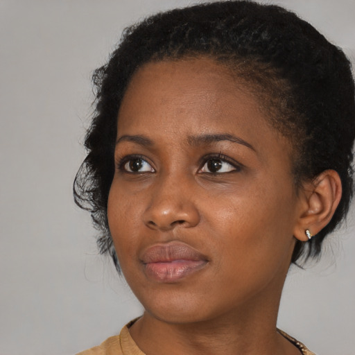 Joyful black young-adult female with medium  brown hair and brown eyes