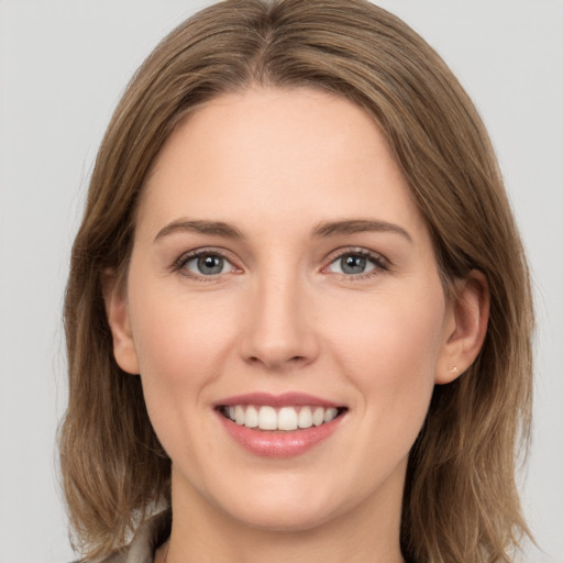 Joyful white young-adult female with medium  brown hair and grey eyes