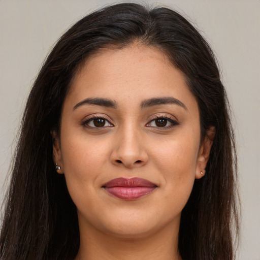 Joyful latino young-adult female with long  brown hair and brown eyes