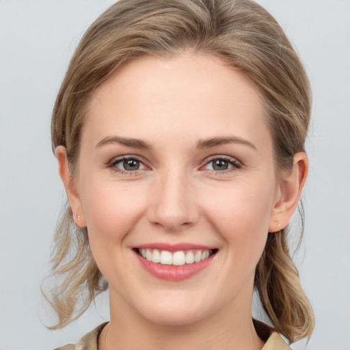 Joyful white young-adult female with medium  brown hair and grey eyes