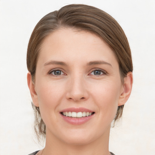 Joyful white young-adult female with medium  brown hair and grey eyes