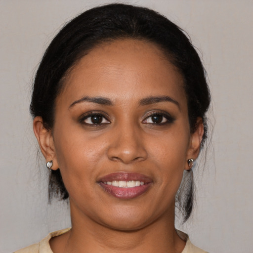 Joyful black young-adult female with medium  black hair and brown eyes