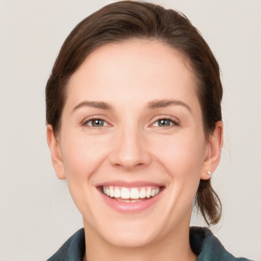 Joyful white young-adult female with medium  brown hair and grey eyes