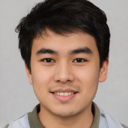 Joyful asian young-adult male with short  black hair and brown eyes