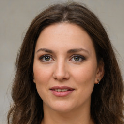 Joyful white young-adult female with long  brown hair and green eyes