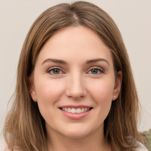 Joyful white young-adult female with long  brown hair and grey eyes