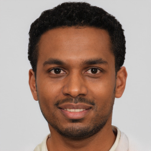 Joyful black young-adult male with short  black hair and brown eyes