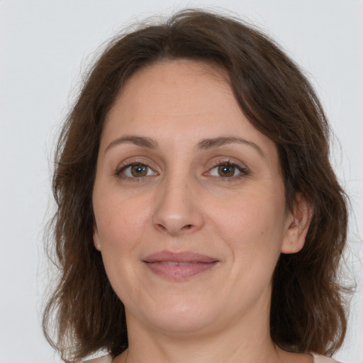 Joyful white adult female with medium  brown hair and grey eyes