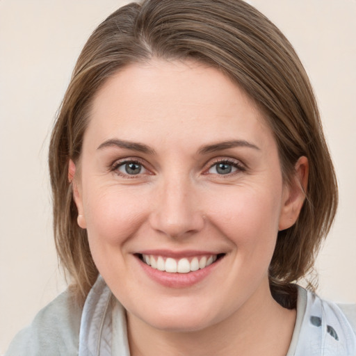 Joyful white young-adult female with medium  brown hair and grey eyes