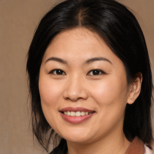Joyful asian young-adult female with medium  brown hair and brown eyes