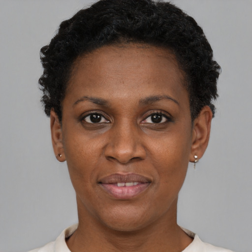 Joyful black young-adult female with short  black hair and brown eyes