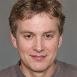 Joyful white adult male with short  brown hair and grey eyes