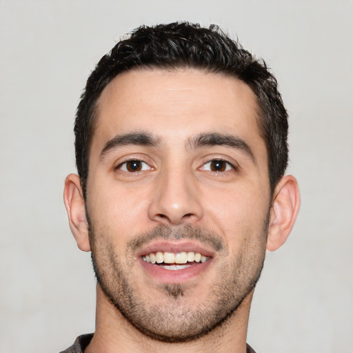 Joyful white young-adult male with short  black hair and brown eyes