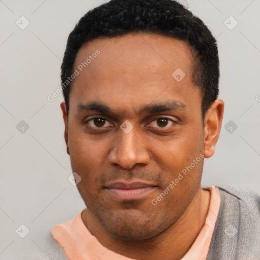 Joyful black young-adult male with short  black hair and brown eyes