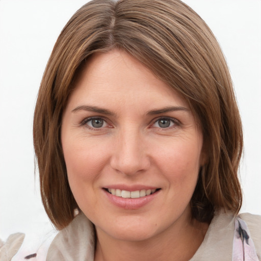 Joyful white young-adult female with medium  brown hair and grey eyes