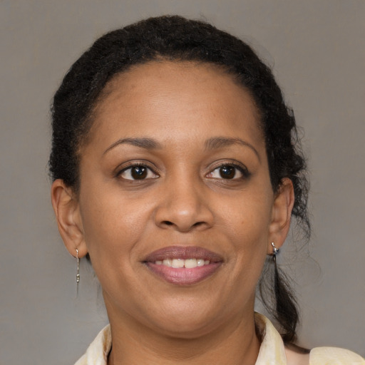 Joyful black young-adult female with medium  brown hair and brown eyes