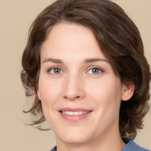 Joyful white young-adult female with medium  brown hair and green eyes