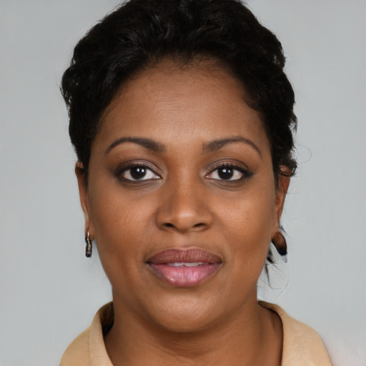 Joyful black adult female with medium  brown hair and brown eyes