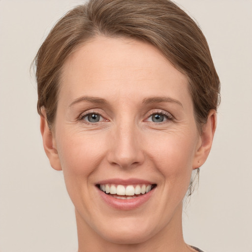 Joyful white young-adult female with short  brown hair and grey eyes