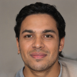 Joyful latino young-adult male with short  black hair and brown eyes