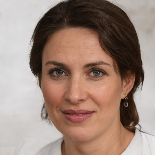 Joyful white adult female with medium  brown hair and grey eyes