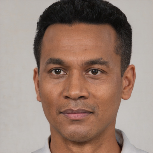 Joyful black adult male with short  black hair and brown eyes