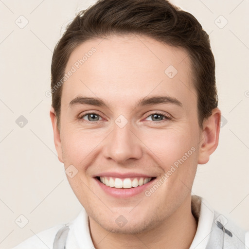 Joyful white young-adult male with short  brown hair and grey eyes