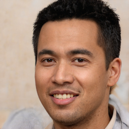 Joyful asian young-adult male with short  black hair and brown eyes