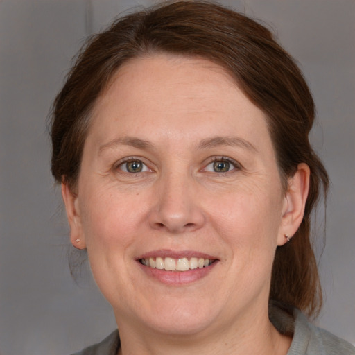 Joyful white adult female with medium  brown hair and grey eyes