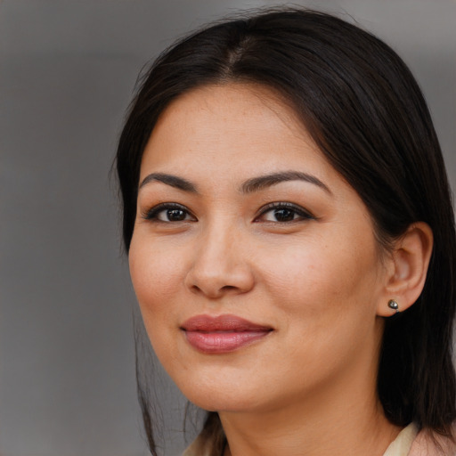 Joyful latino young-adult female with long  brown hair and brown eyes