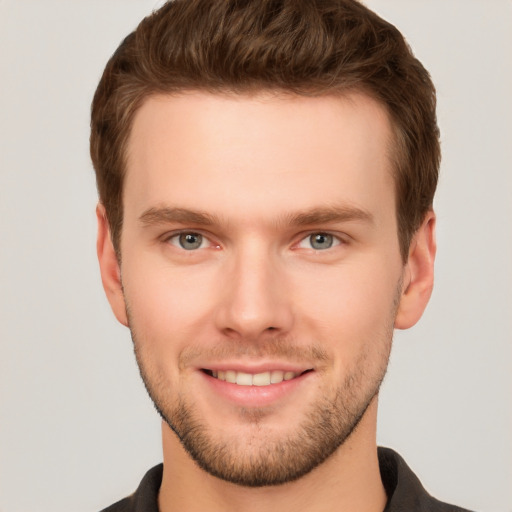 Joyful white young-adult male with short  brown hair and grey eyes