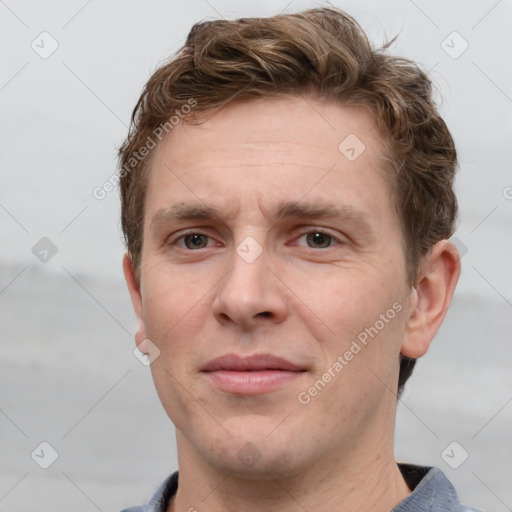 Joyful white adult male with short  brown hair and grey eyes