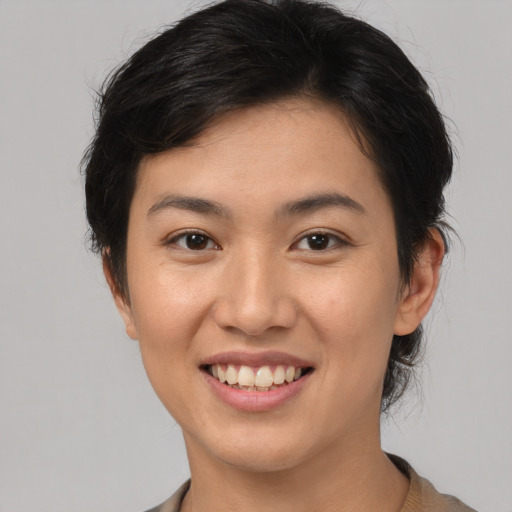 Joyful asian young-adult female with short  brown hair and brown eyes