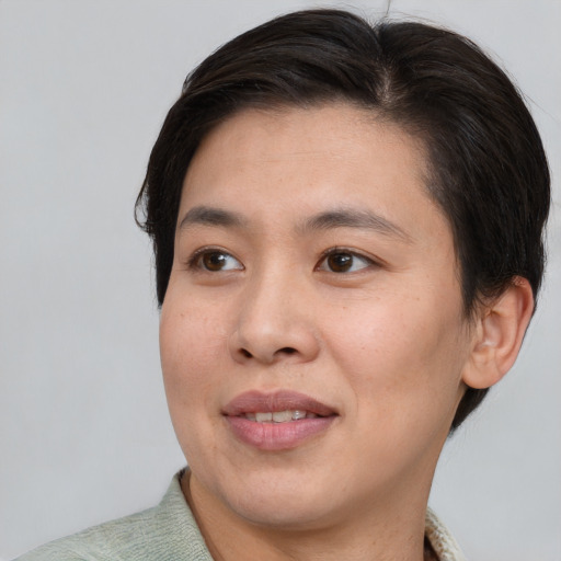Joyful asian young-adult female with short  brown hair and brown eyes