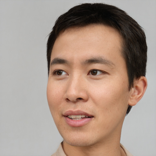 Joyful asian adult male with short  brown hair and brown eyes