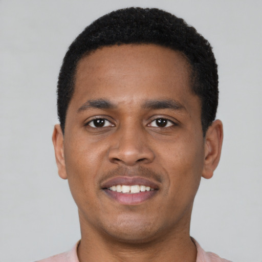 Joyful black young-adult male with short  black hair and brown eyes